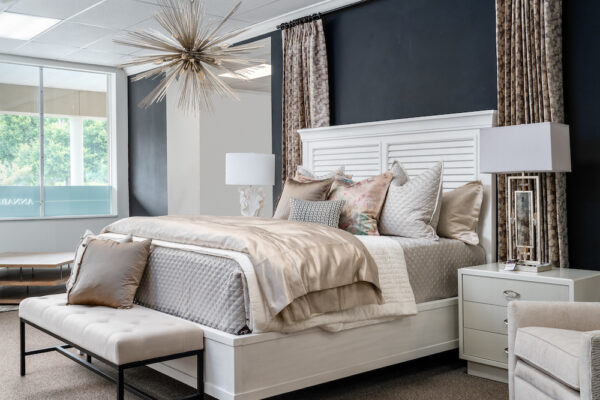 Tampa interior designers crafted a bedroom using a Surya lamp and chandelier, Vanguard nightstands, and a Gabby bench.