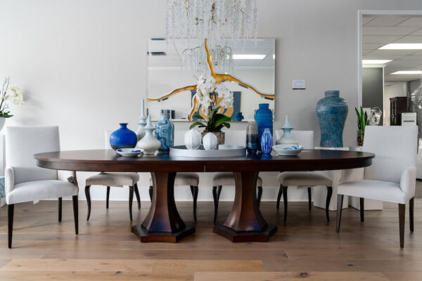 A dining room is designed with a John-Richard chandelier, a dining room table by Bernhardt and Lita vases.