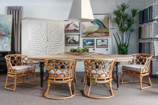 A high-end dining room is furnished with Gabby dining chairs and dining table, a Caracole bar cabinet and Wendover art.