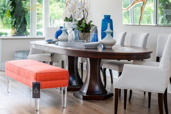 A luxury dining room is designed to be synthesized with John-Richard art, Century side chairs and a Livery bench.