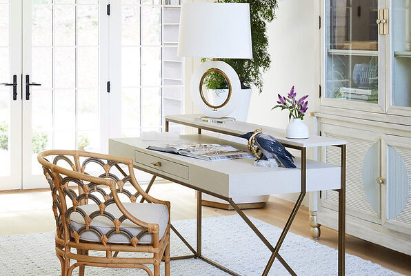 The Coralee dining rattan chair and cerused white wooden desk with antique brass framing by Gabby.