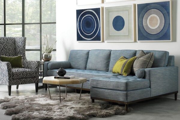 Hickory White Charlotte sectional with chaise paired in a living room with statement chair, cocktail table, rug, & wall art.